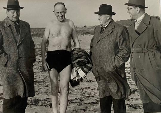 Krister Lund från Brunnby, 60 år gammal, vinterbadar i Strandbaden den 1 december 1953. Övriga på bilden är Brunnby kommunalnämndsordförande Vilhelm Lundqvist, kommunalkamrer Knut Freigard och förste sekreteraren i landskommunernas förbund fil. d:r John Olsson, Stocksund.